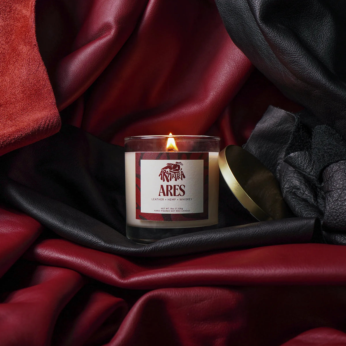 Candle labeled 'Ares' on a dark fabric background