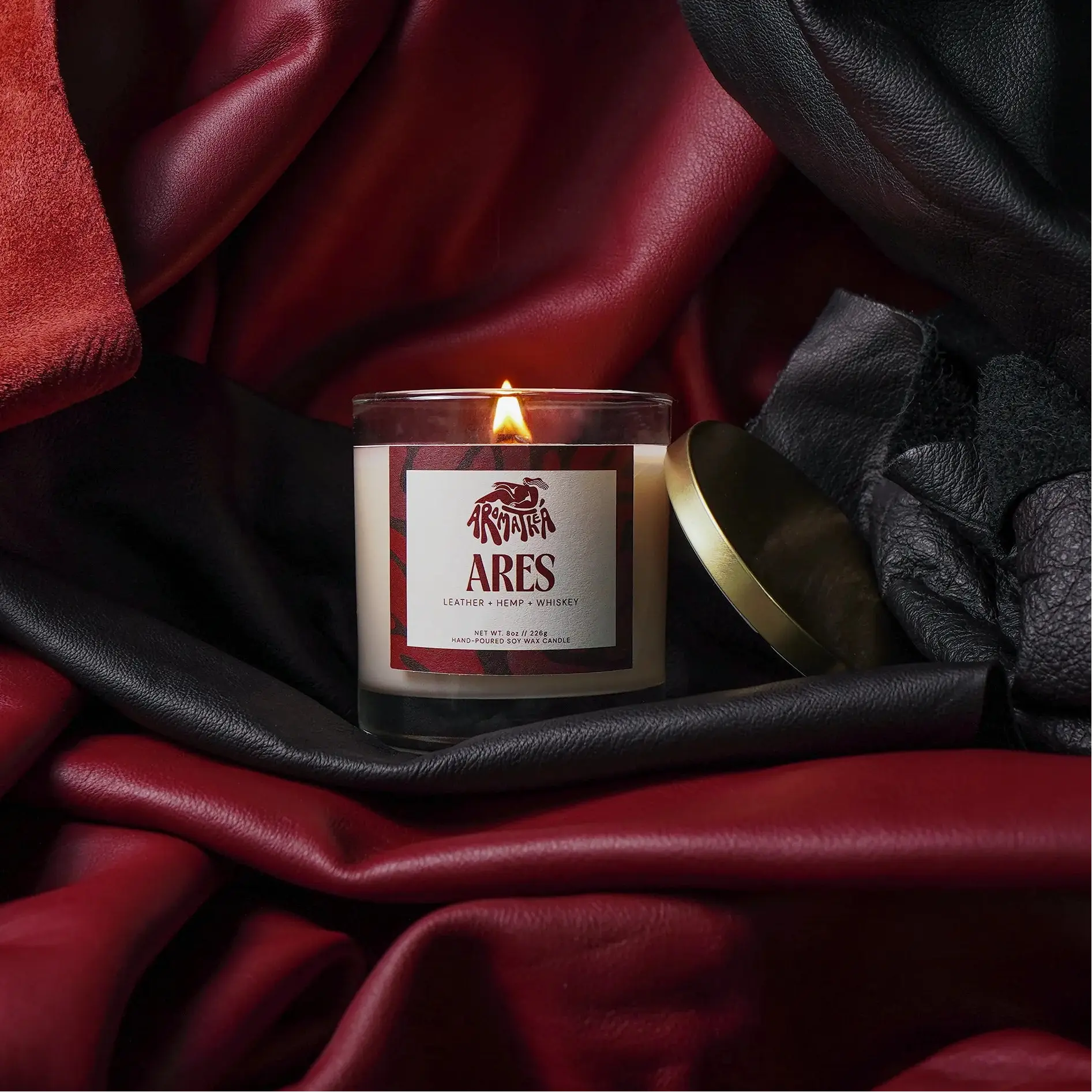 Candle with a 'Ares' label on red and black fabric
